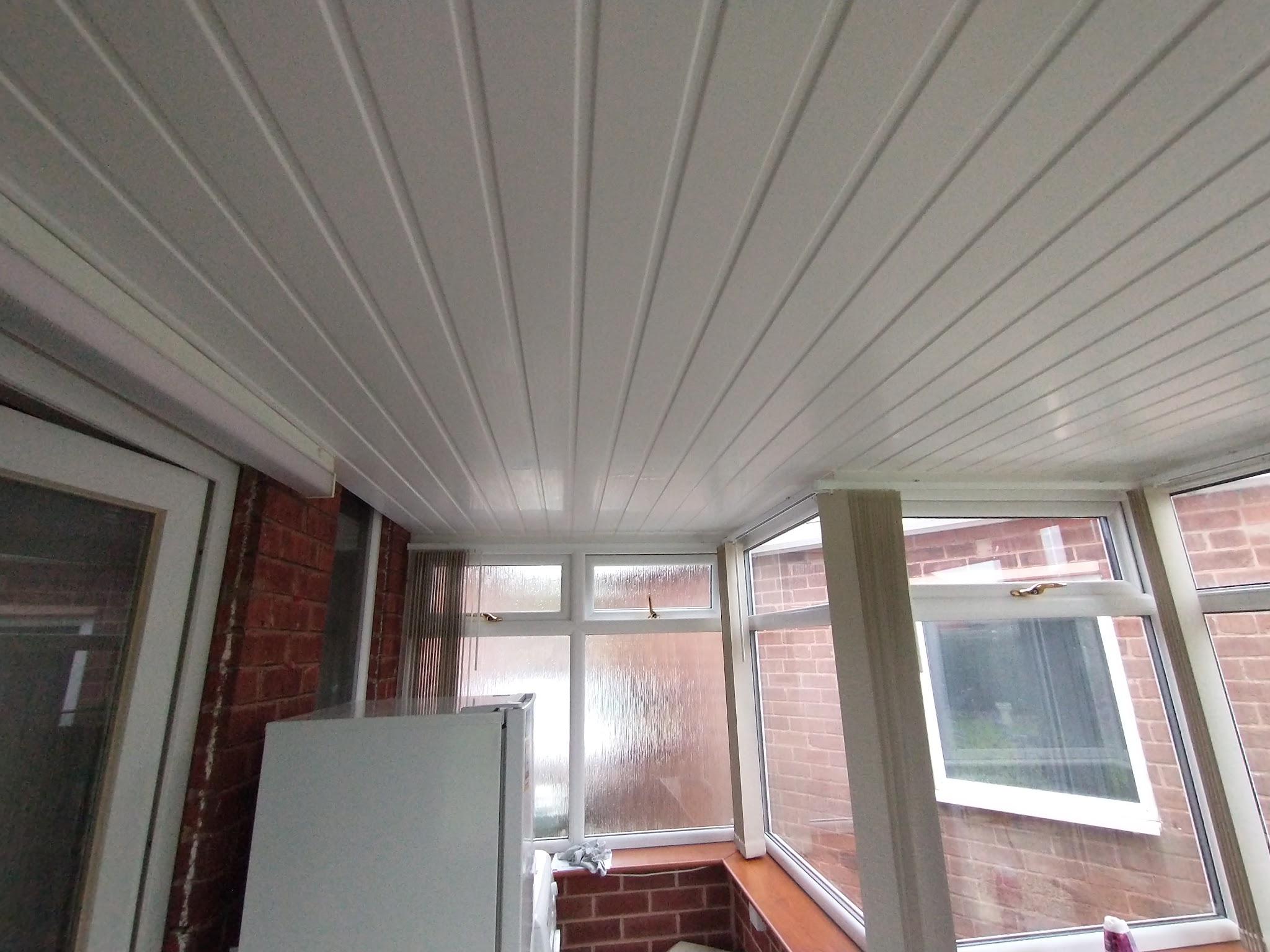 Inside the conservatory under a new white panelled ceiling