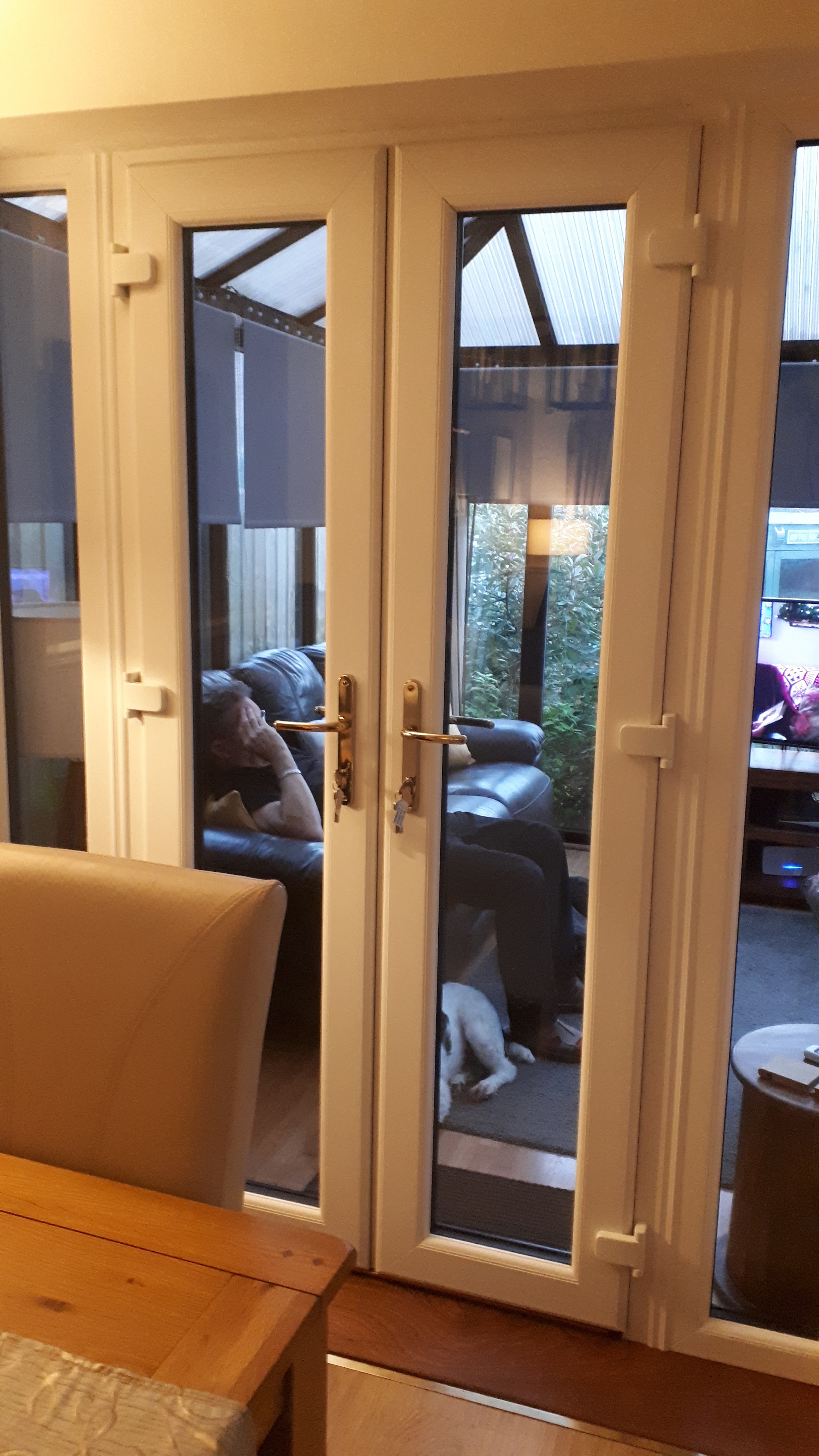 White internal French doors opening from a dining room into a conservatory